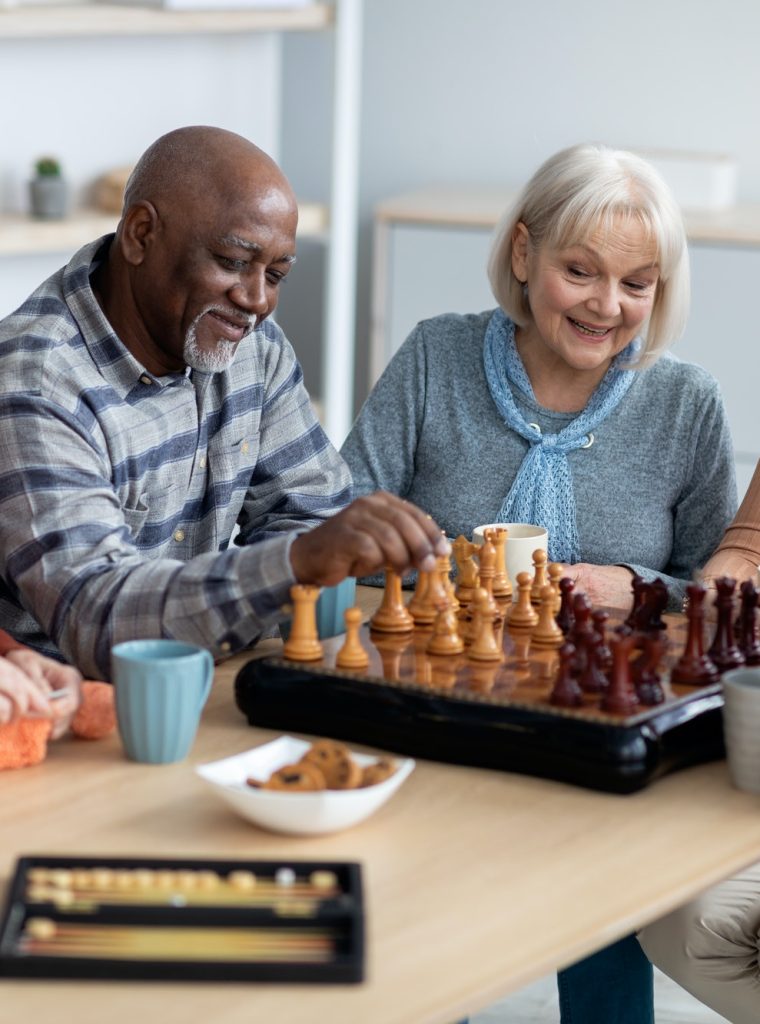 Multiracial senior people playing chess at nursing home